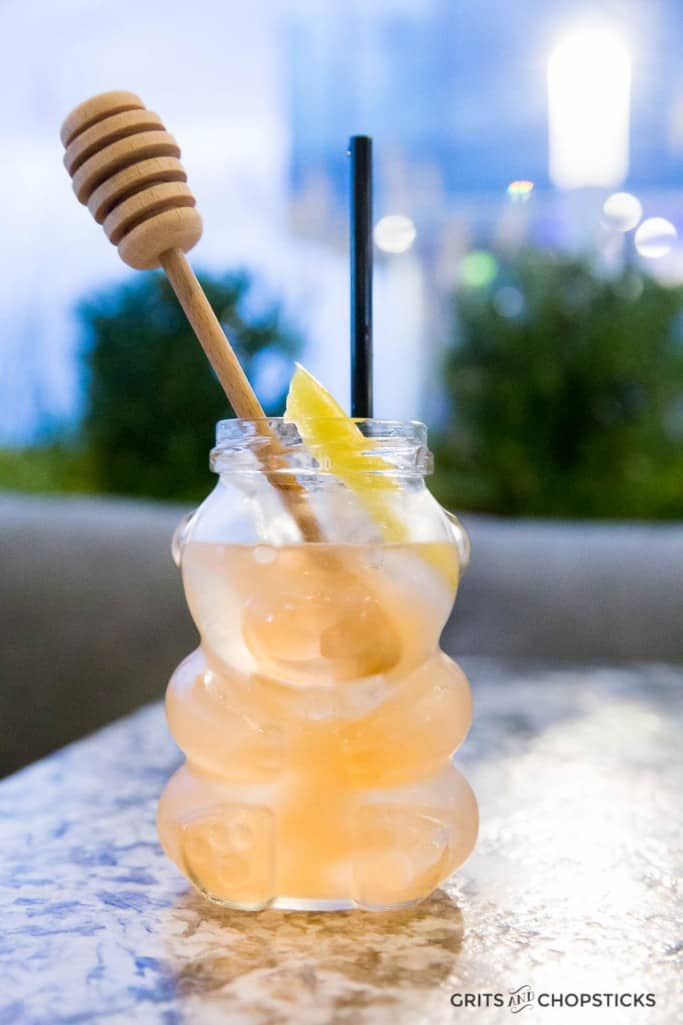 The Bee's Knees Cocktail at Earl's Kitchen + Bar is served in a honey bear jar with a honeycomb stirrer -- a cheeky yet sophisticated twist on a classic gin cocktail